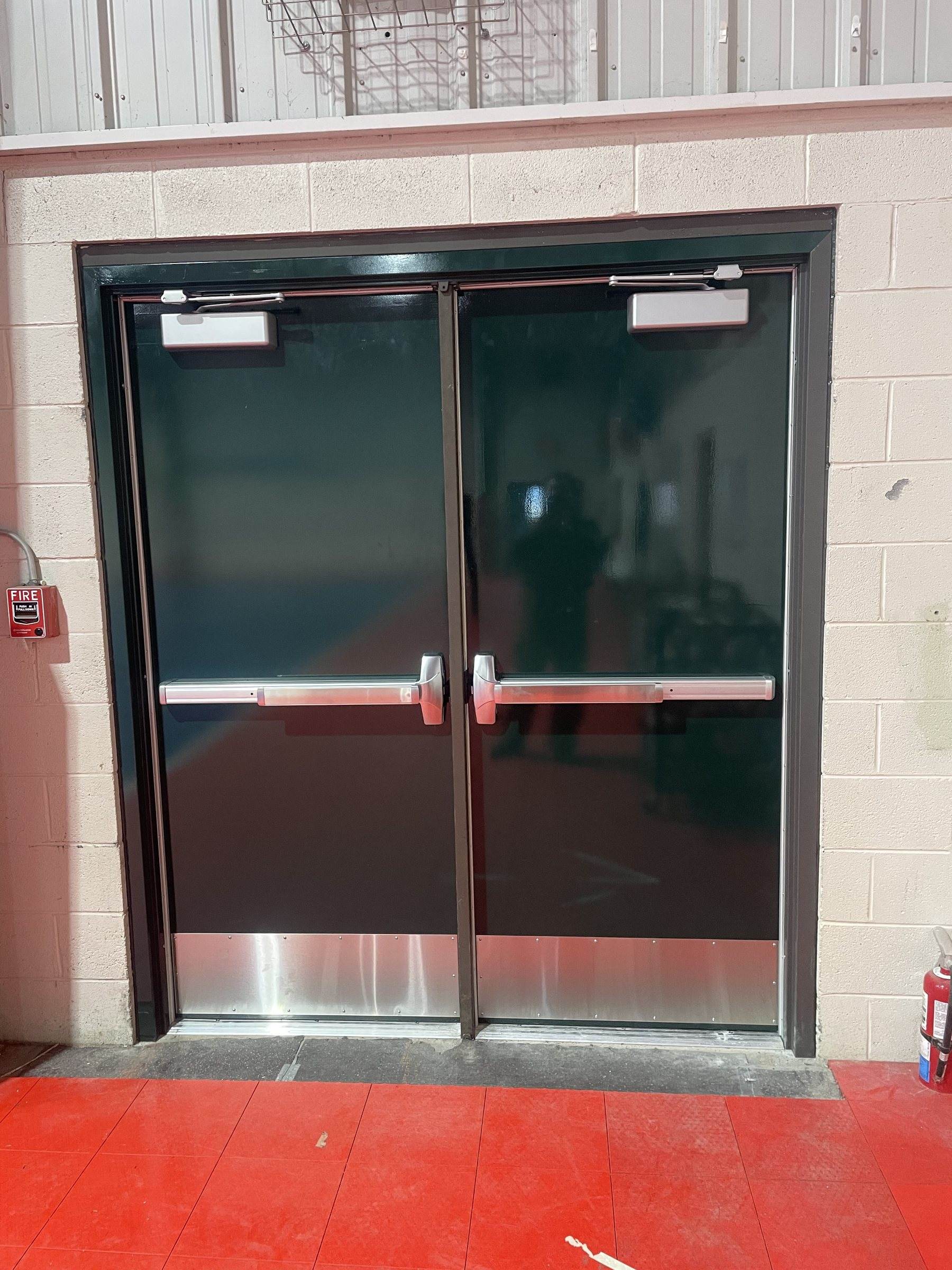 Hollow metal double doors with panic bars and kick plates