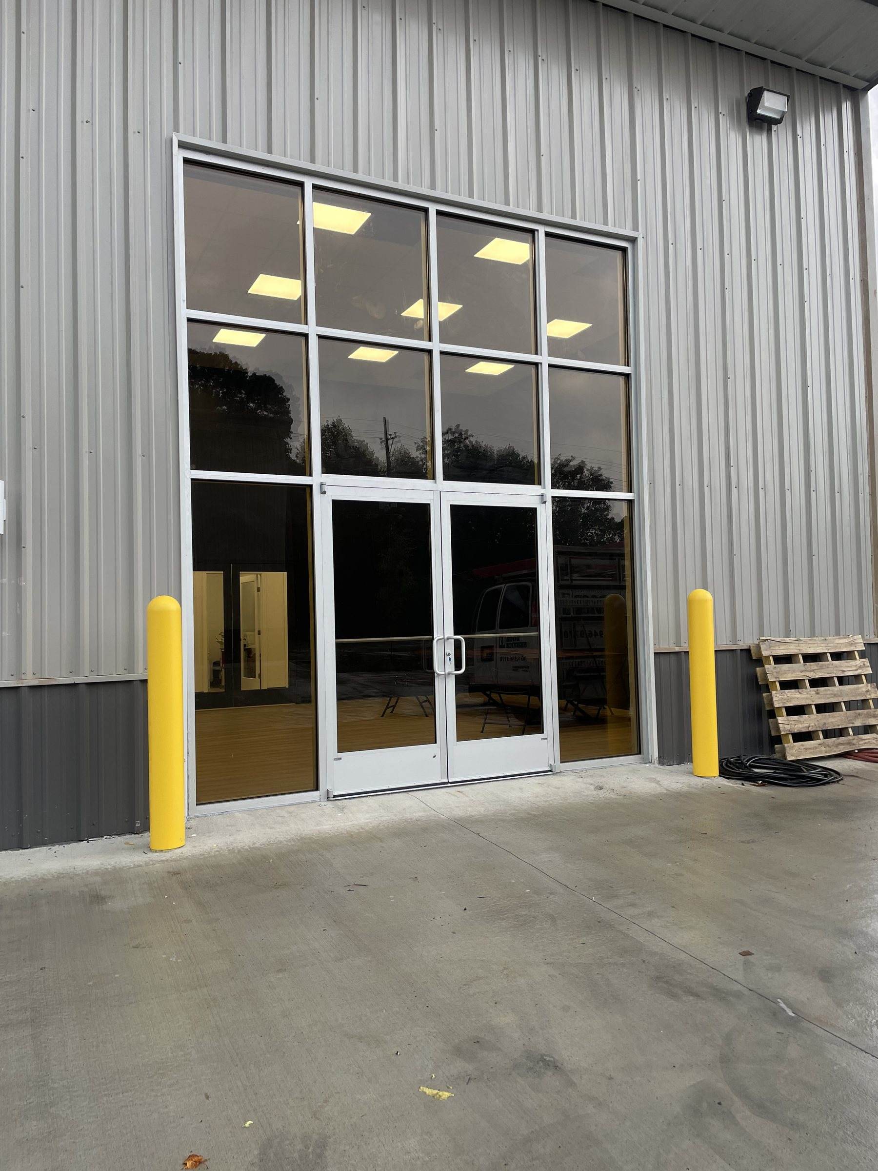 Aluminum storefront with tall glass panels in a corrugated steel building