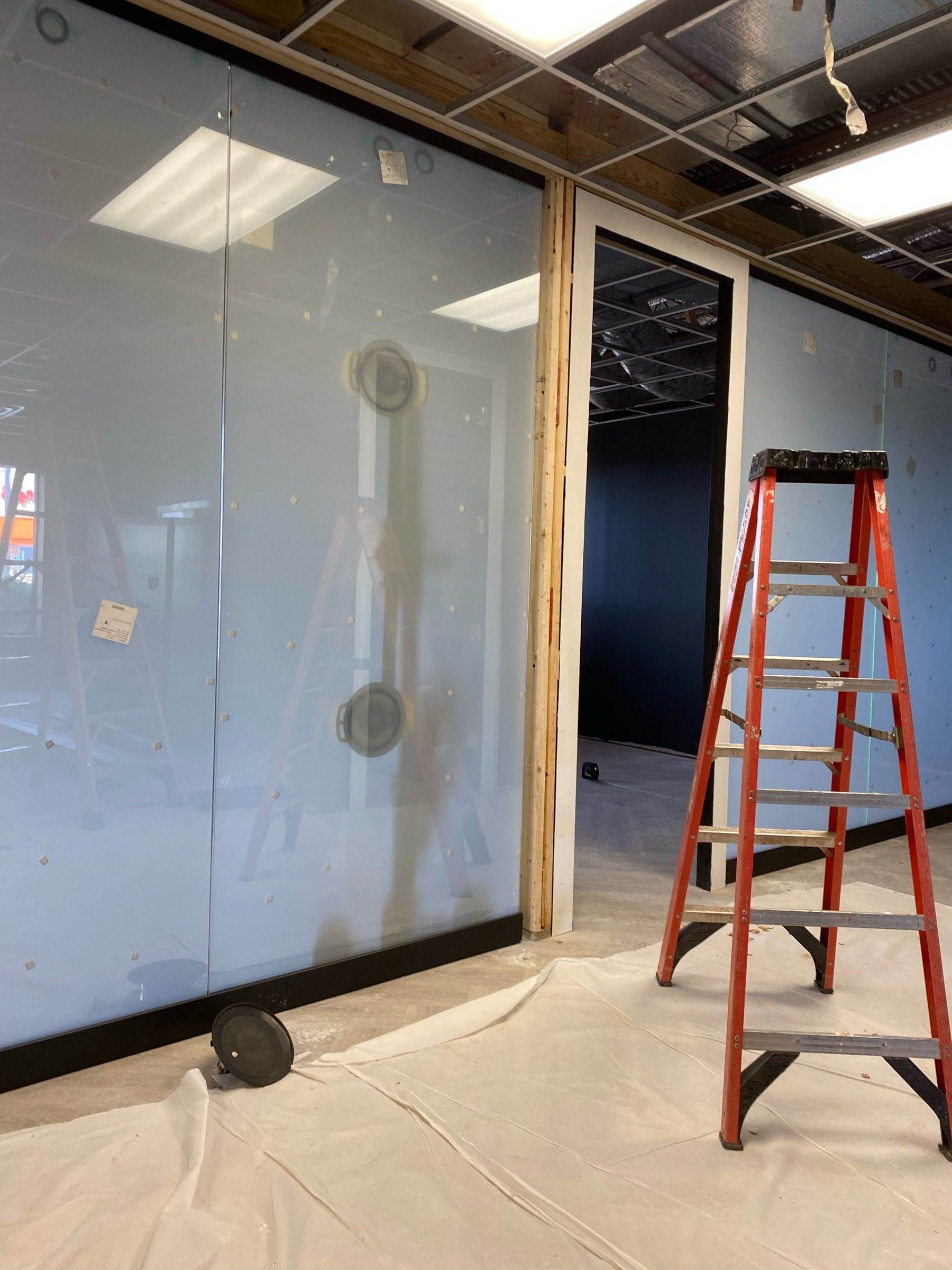 Switchable privacy glass partition being installed in an office